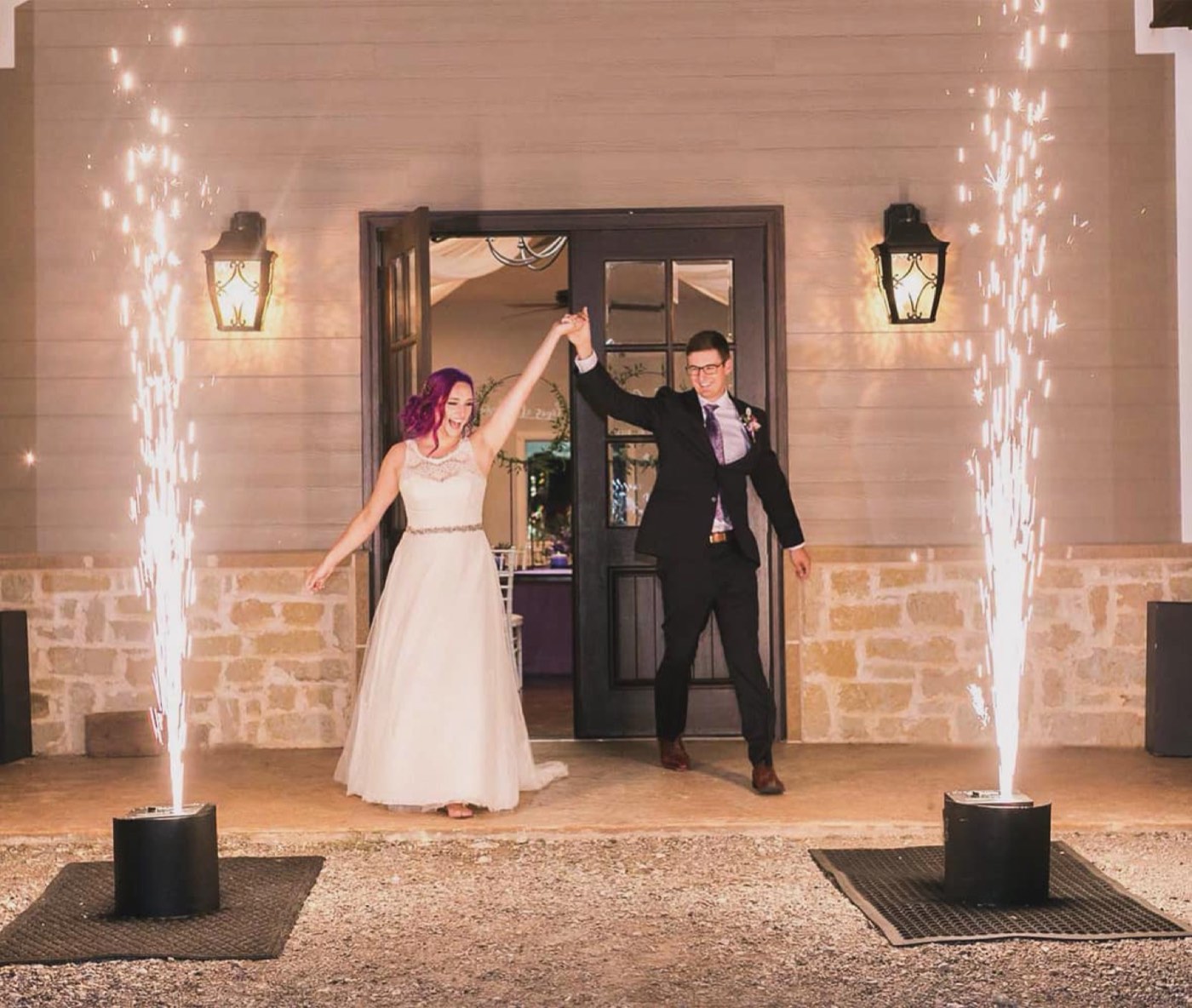 A couple's grand entrance between cold spark fountains