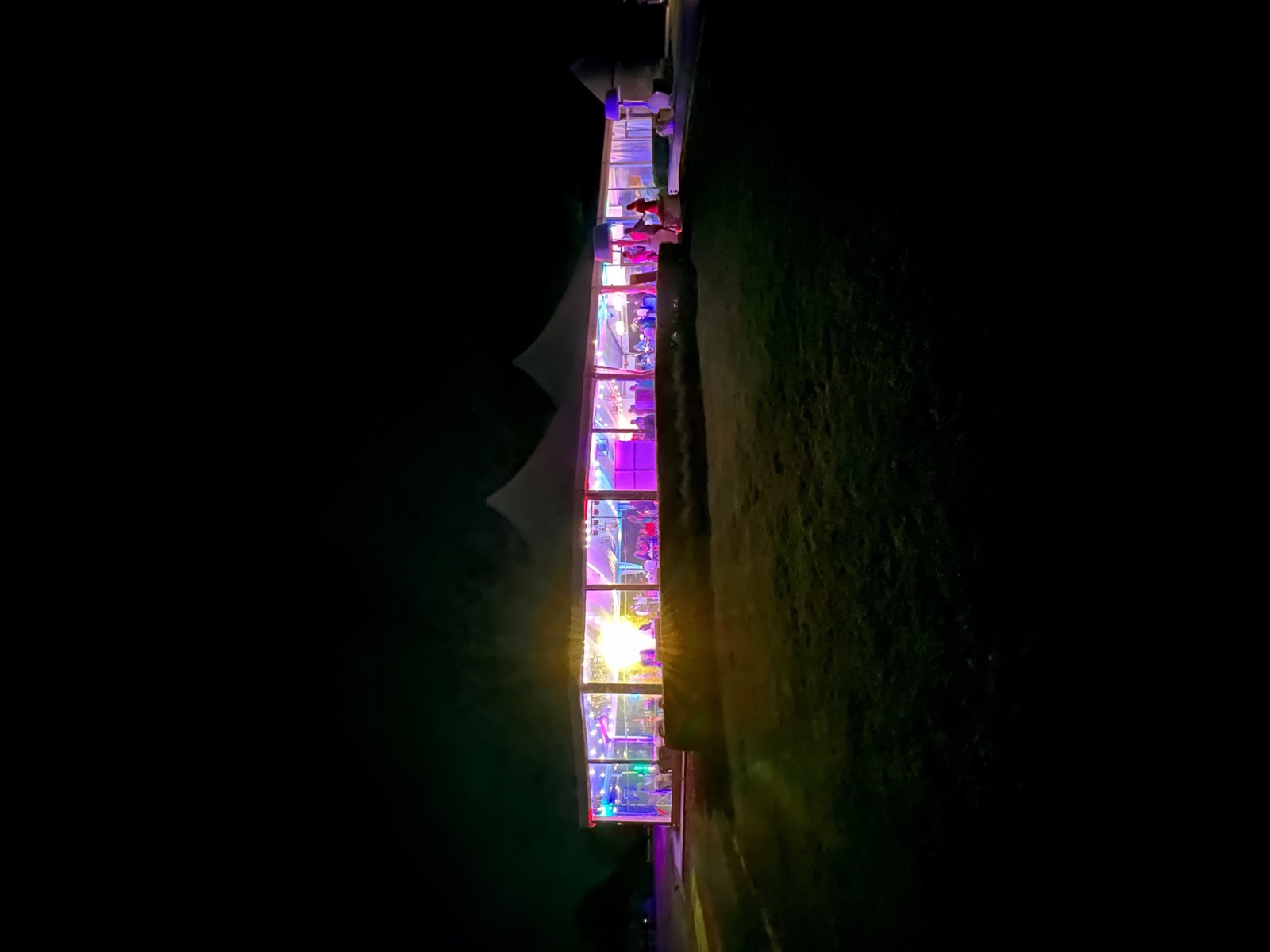 A wedding tent glowing in a dark field